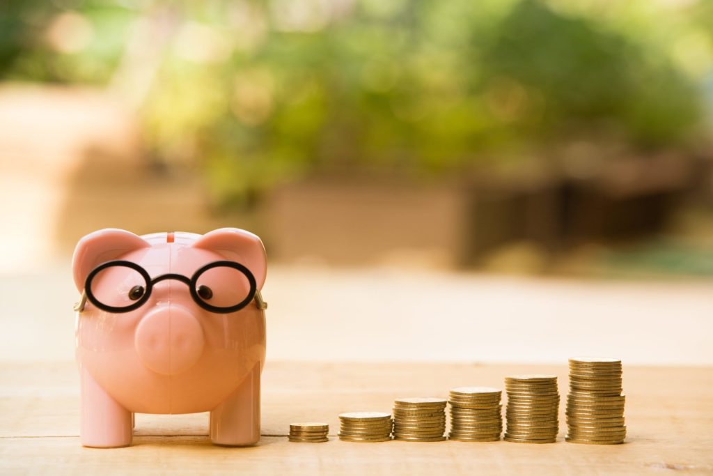 Berufsunfähigkeit wie hoch: Sparschwein mit Brille und Geldstapel. 